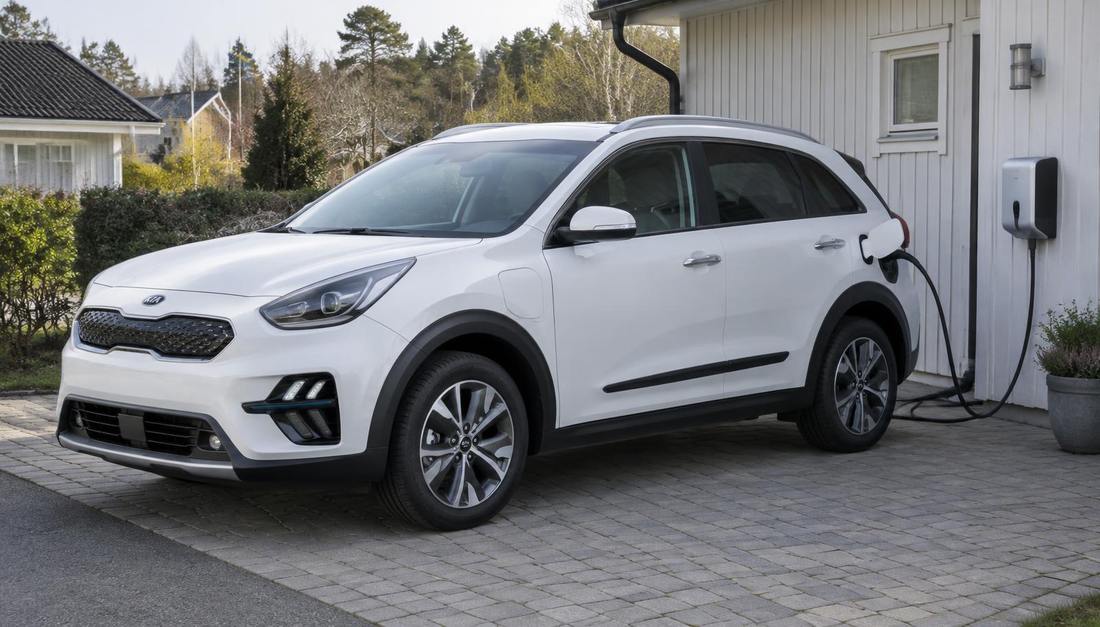 Kia Niro laddhybrid laddar via laddbox på en uppfart i ett svenskt villaområde